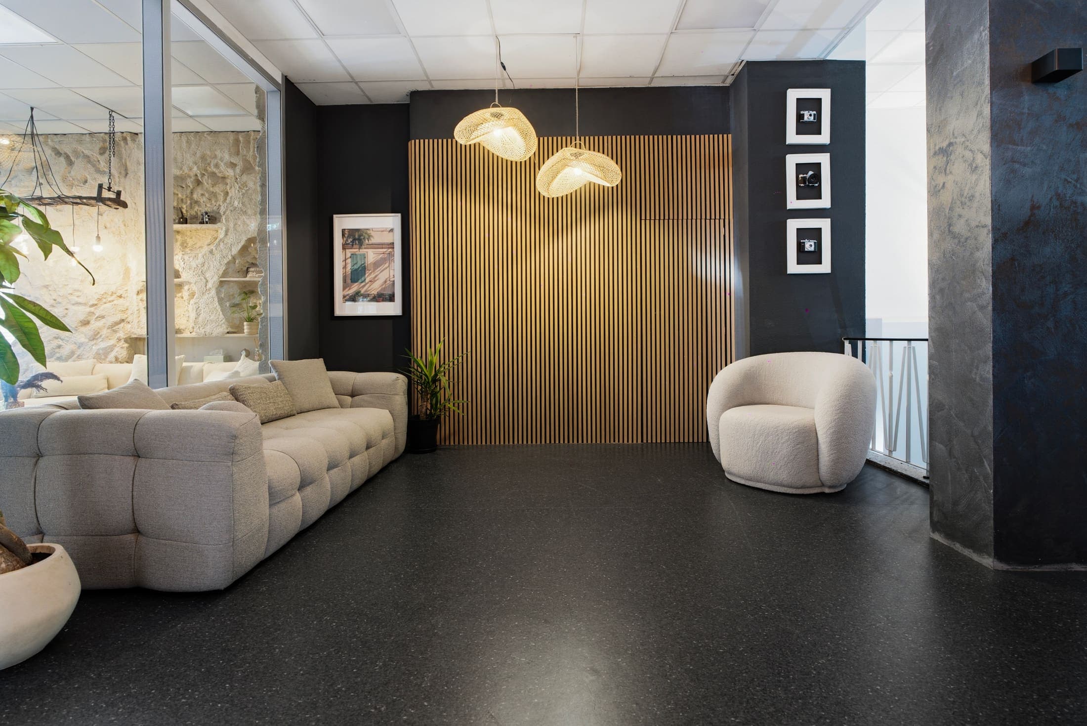 Lounge-Kulisse mit cremefarbenem Sofa, Design-Sessel und goldener Akzentwand